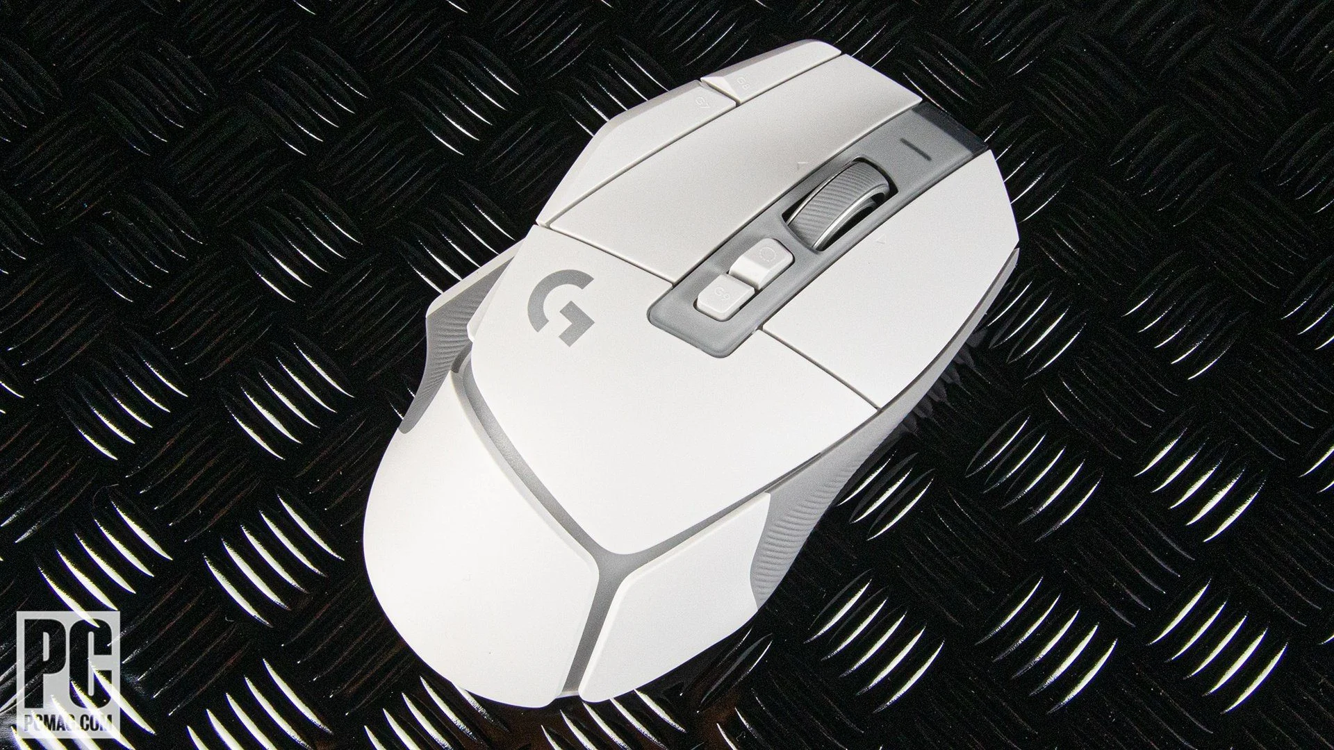 A gaming mouse pad lying flat on a towel on a drying rack, air-drying